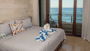 Ein Hotelzimmer mit Bett, Meerblick und einem Balkon mit Stuhl.