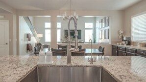 Een keuken met granieten aanrechtbladen, een roestvrijstalen spoelbak en een moderne kraan.