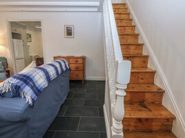 A bedroom with a bed, a dresser, and a staircase.