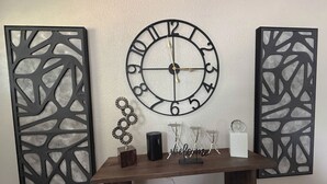 Une horloge murale au design circulaire, agrémentée de panneaux décoratifs aux motifs découpés.