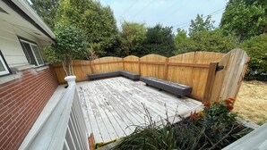 A wooden deck with built-in seating and a brick wall. - Charming villa with AC in Renton - perfect for large groups (Renton)
