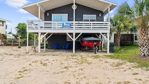 A two-story building with a covered deck and a sign indicating it is a beach house. - The Beach Bungalow by Book That Condo (Panama City Beach)