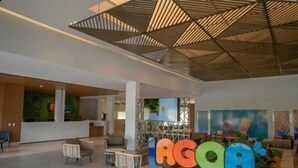 Een moderne lobby met een receptiebalie, een zithoek en een groot bord met 'Lagoon Eco Towers'.