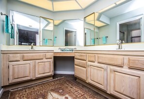 Une salle de bain avec deux lavabos, de grands miroirs et des meubles en bois.