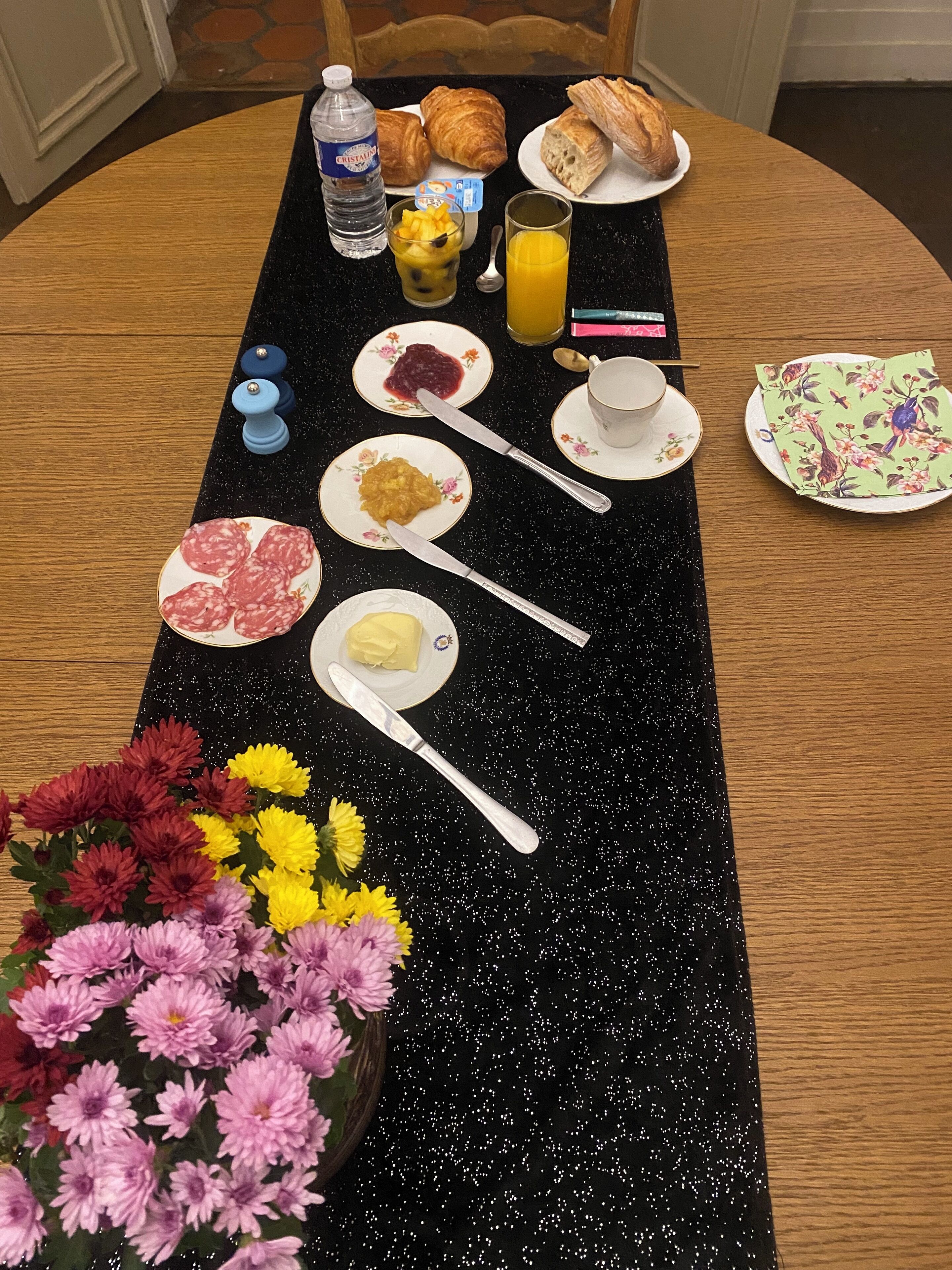 A breakfast table with croissants, juice, and various spreads.