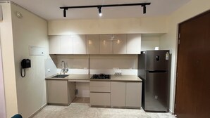 A compact kitchen with a gas stove, sink, and a refrigerator.
