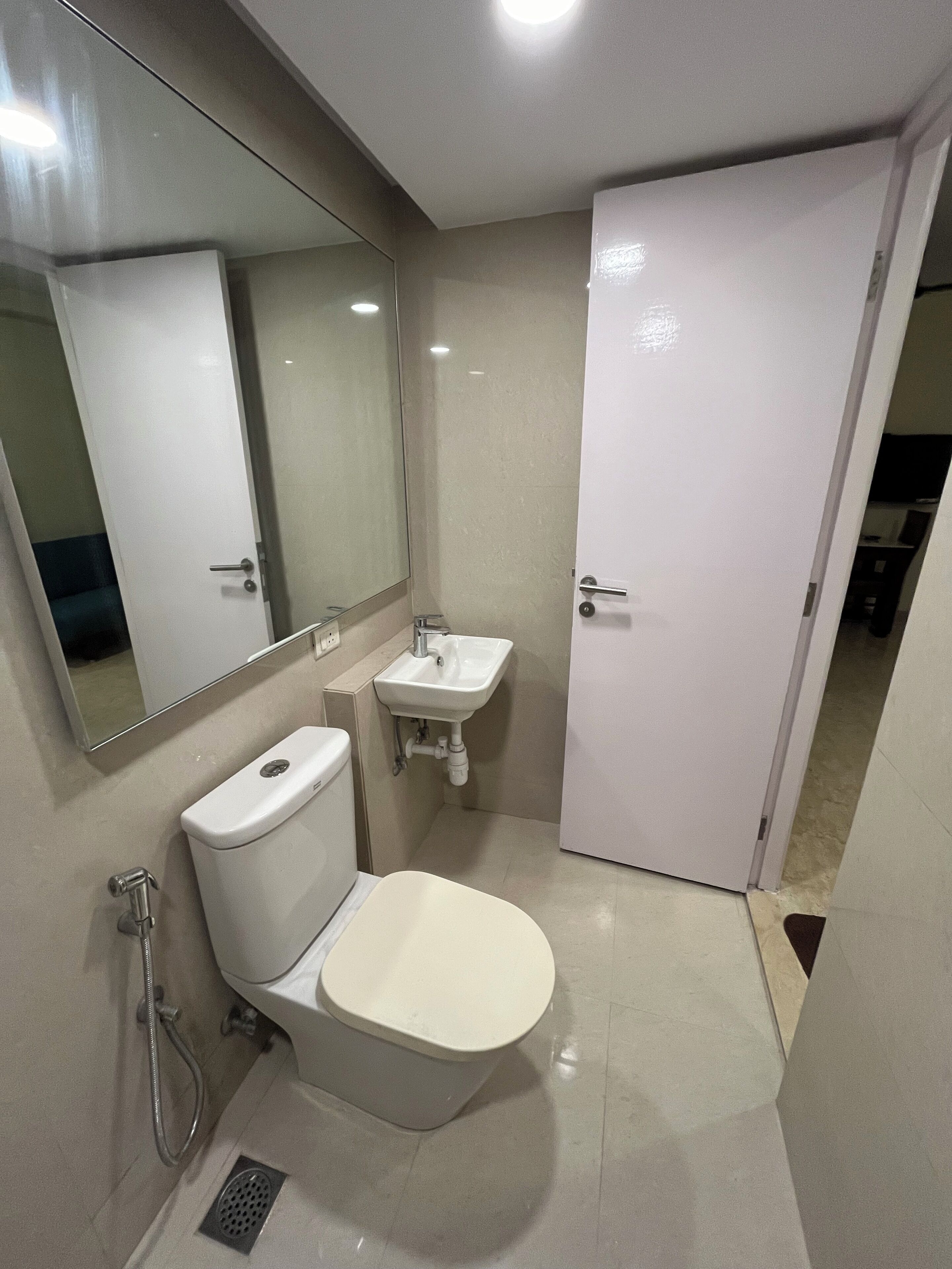 Une petite salle de bain comprenant des toilettes, un lavabo et un miroir.