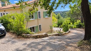 A house with a stone wall, green shutters, and a gravel driveway. - Villa Magrado - Breathtaking views of the vineyards - private, fenced-in pool. (Entrecasteaux)