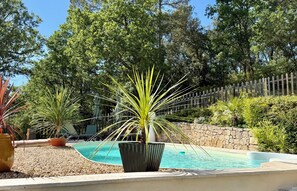 A pool surrounded by potted plants and a stone wall. - Family villa - Breathtaking view of the vineyards - private, fenced pool. (Entrecasteaux)