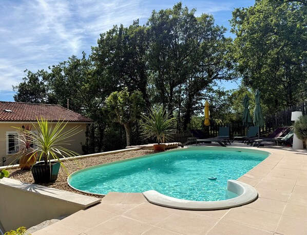A swimming pool with a tiled deck, surrounded by trees and a fence. - Family villa - Breathtaking view of the vineyards - private, fenced pool. (Entrecasteaux)