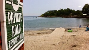 A beach with a sign reading "PRIVATE ROAD RESIDENTS ONLY".