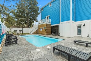 Une piscine avec des chaises longues et un espace patio.