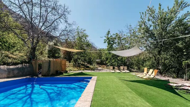 A backyard with a swimming pool, artificial grass, and lounge chairs. - Cabaña Jacuzzi Interior (San Alfonso)