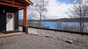 Une cabane en bois avec vue sur un lac et des collines.