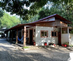 A house with a covered porch, a hammock, and potted plants. - Oceanfront Artistic Escape in Cabuya (Cabuya)