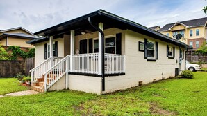 Ein eingeschossiges Haus mit überdachter Veranda, Vorgarten und Satellitenschüssel.