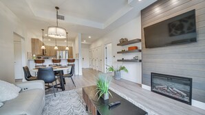 A modern living room with a sofa, dining area, and fireplace. - Suncadia Resort Condo Near Trails & River Access! (Cle Elum)