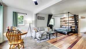 A modern room with a bed, sofa, dining table, and a ceiling fan. - Private UP Escape Near Lake Superior (Pelkie)