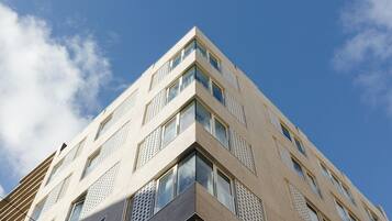 Ein modernes Gebäude mit Eckblick, mit zahlreichen Fenstern und blauem Himmel.