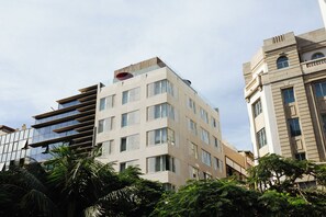 Un edificio de varios pisos con un diseño arquitectónico moderno, que cuenta con balcones y ventanas amplias.