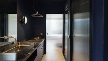 Un baño moderno con un espejo grande, un lavabo y un perchero para toallas.