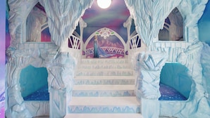 Un escalier dont les murs ressemblent à de la glace et sur lequel est peint un portrait d’un personnage.