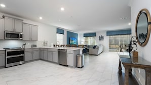 Une cuisine moderne avec des meubles gris, des appareils en acier inoxydable et un îlot central.