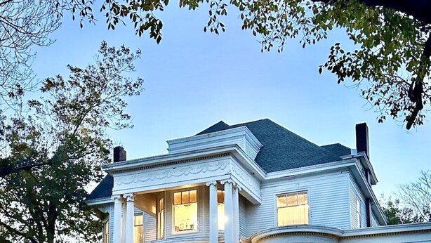 A large, two-story house with a wrap-around porch, columns, and a well-maintained lawn. - The Lynnie Ann at The Judge`s Chamber (Guthrie)