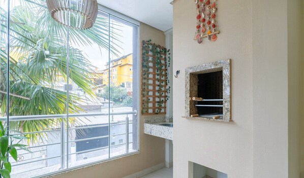 A kitchen with a window, a hanging plant, and a decorative shell wall piece.