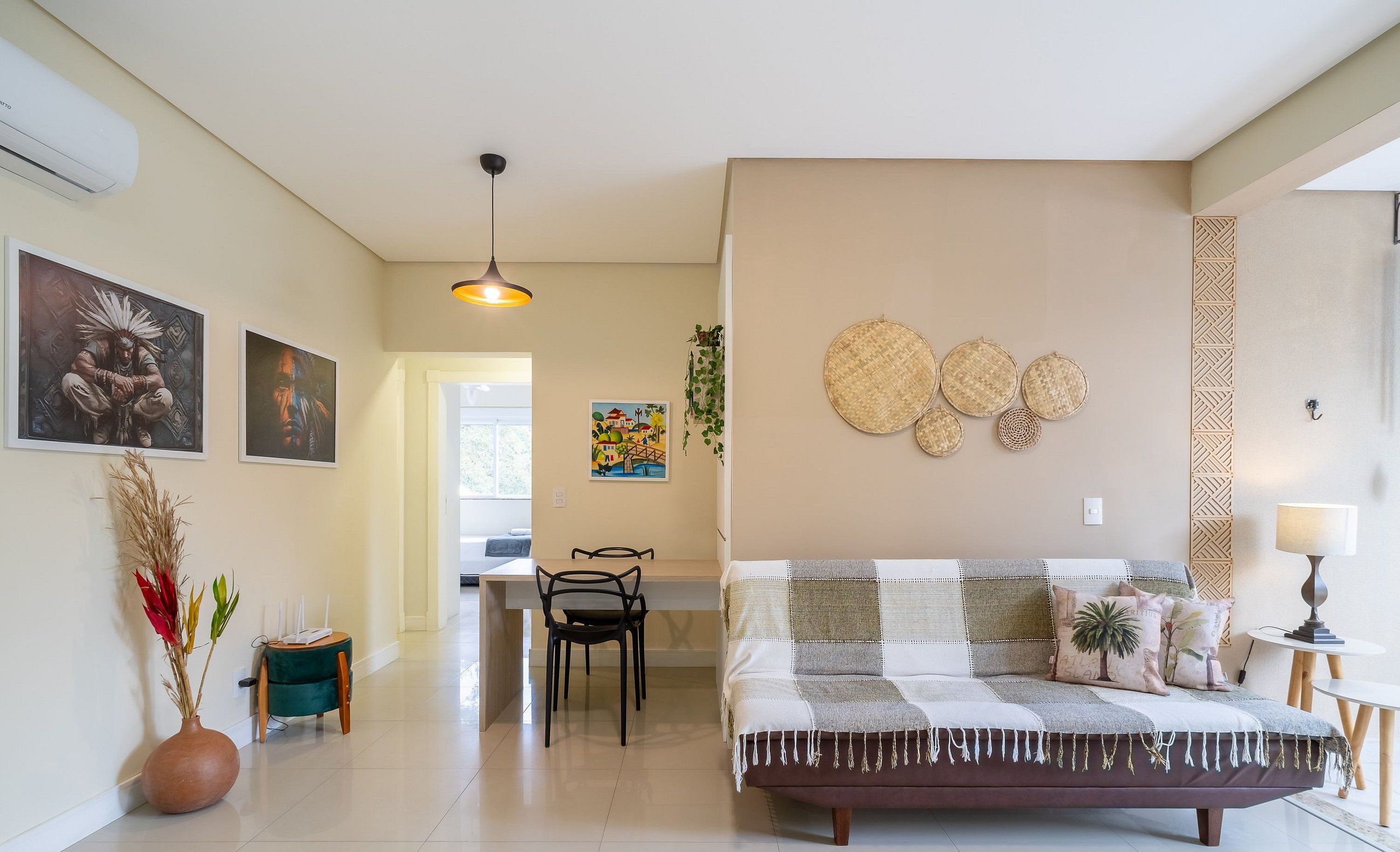 Una sala moderna con un sofá, un comedor con sillas y una cocina al fondo.