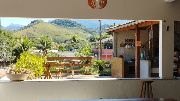 A dining area with a view of a mountainous landscape. - Pousada Solar Bananeiras (Silva Jardim)
