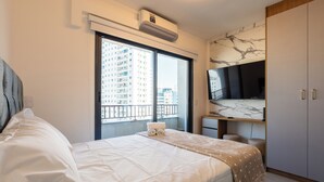 Une chambre d’hôtel équipée d’un lit, d’une grande fenêtre, d’un climatiseur, d’une télévision et d’une armoire.