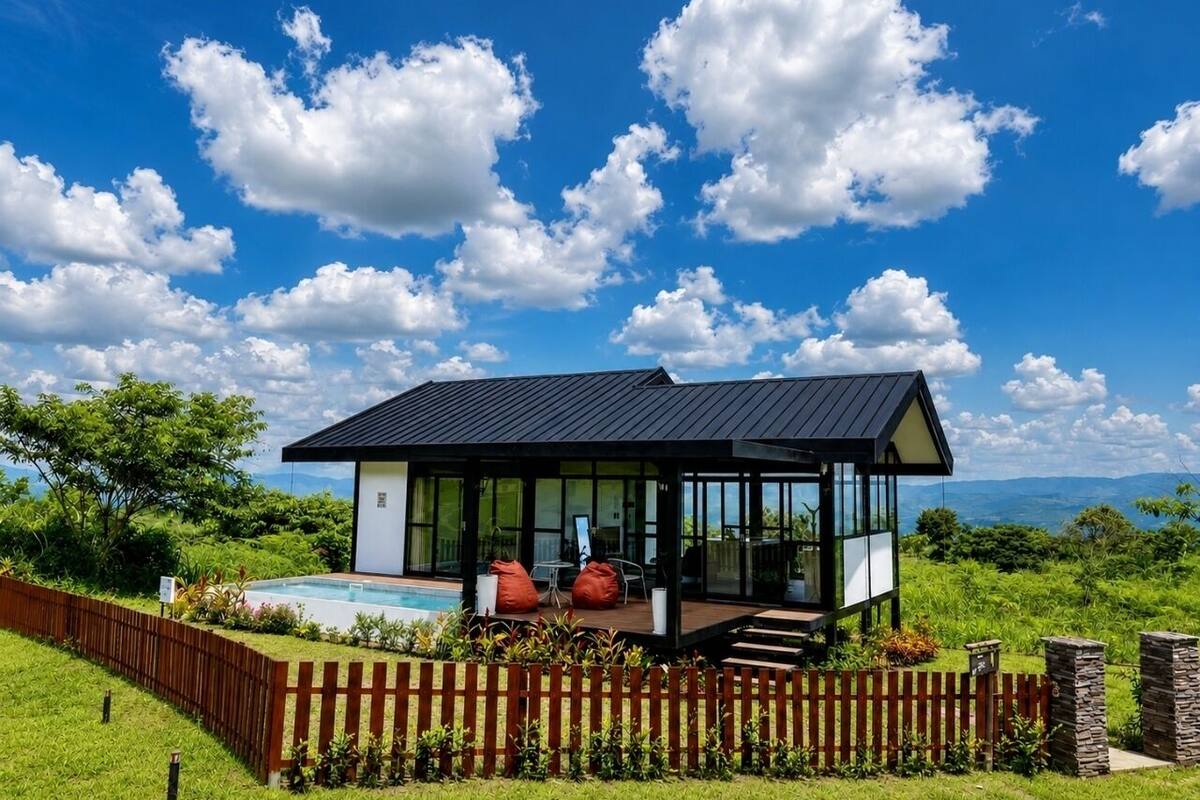 Una casa moderna con piscina, mobiliario exterior y vistas al paisaje.
