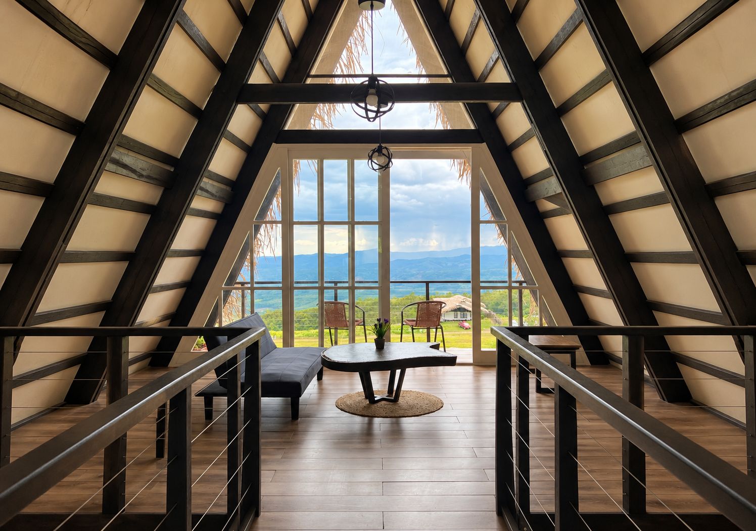 Ein geräumiger Raum mit hoher Decke und großen Fenstern, der einen Ausblick ins Freie bietet.