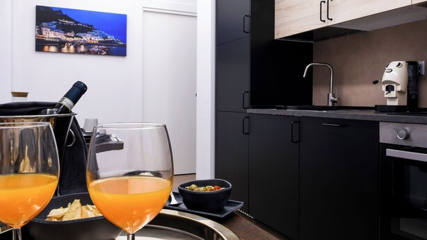 A modern kitchen with a coffee machine, a wine glass, and a bowl of olives on a tray. - CASA VACANZA BENVENUTO
2-bedroom,2-bathroom apartament in adorable Salerno (Salerno)