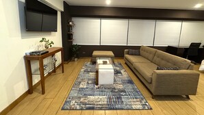 Un soggiorno con un divano, un tavolino e una TV a parete.
