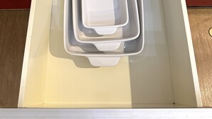 Un cassetto della cucina con contenitori bianchi.
