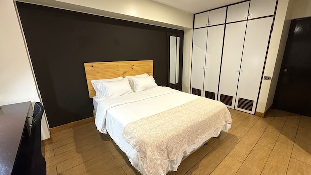 Una camera da letto con un letto, un armadio e uno specchio.