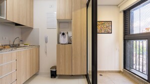 Une cuisine moderne avec des meubles en bois, une machine à café intégrée et une grande fenêtre offrant une belle vue.