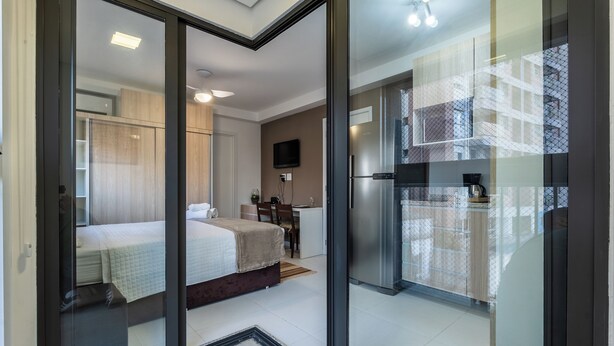 Une chambre d’hôtel moderne équipée d’un lit, d’un bureau et d’une kitchenette.