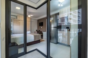 A modern hotel room with a bed, desk, and kitchenette. - Spin Mood Vila Mariana (São Paulo)