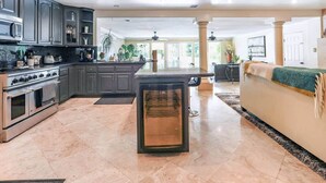 A spacious kitchen with modern appliances, a dining area, and a living room with a large window.