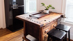 A kitchen with a wooden island, a black refrigerator, and a potted plant. - Charming Oklahoma City Apartment in Central OKC (Oklahoma City)