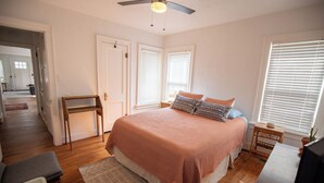 A bedroom with a bed, a desk, a chair, and a window with blinds. - Charming Oklahoma City Apartment in Central OKC (Oklahoma City)