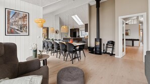 Un soggiorno moderno con zona pranzo, camino e vista sulla cucina.