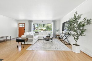 Un salon moderne avec un canapé blanc, une table basse et une plante en pot.