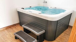 Un jacuzzi con asiento integrado y escalones para facilitar el acceso.