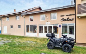 Ein Gebäude mit einem Schild, auf dem 'Salas' steht, und einem schwarzen ATV davor geparkt.
