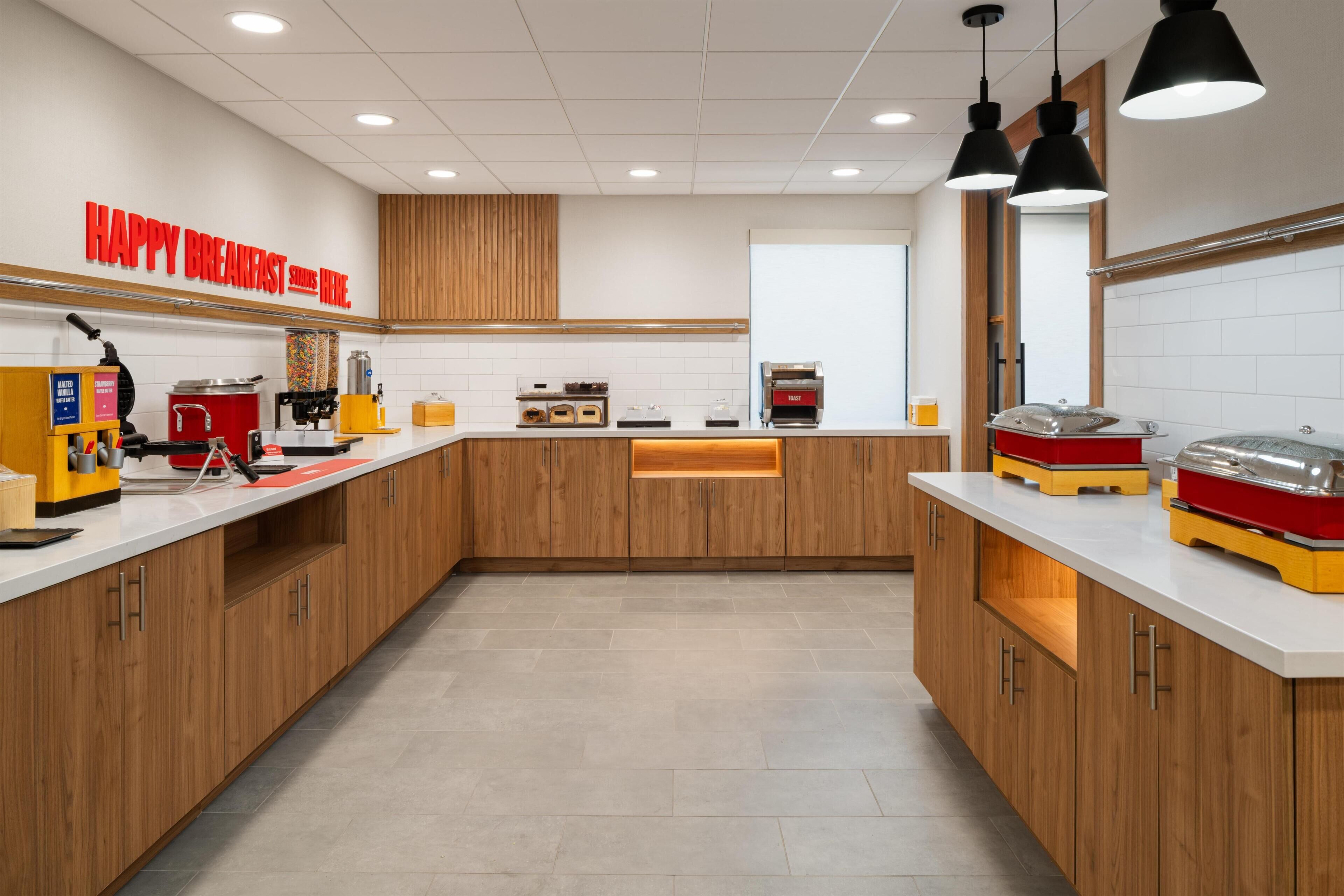 A modern kitchen with wooden cabinets, a coffee machine, and a toaster.