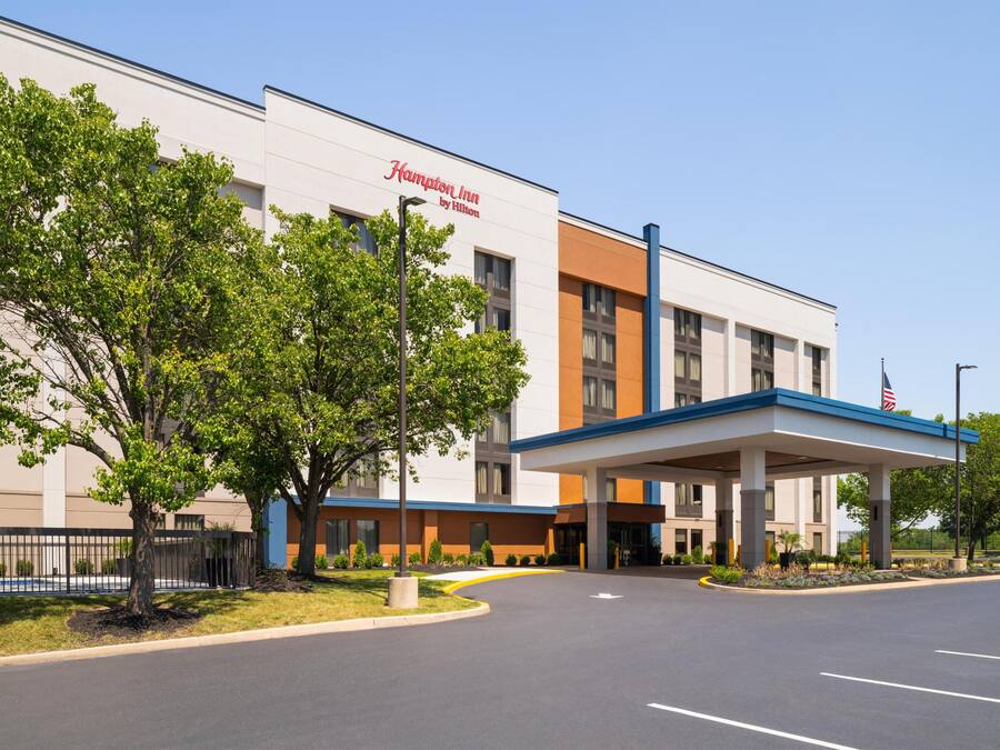 A Hampton Inn by Hilton hotel with a covered entrance and a parking lot.